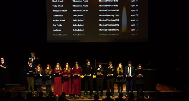 Students reading from a scroll of names at the Holocaust Memorial Day Commemoration. Photo: Dara Mac Dónaill / The Irish Times
